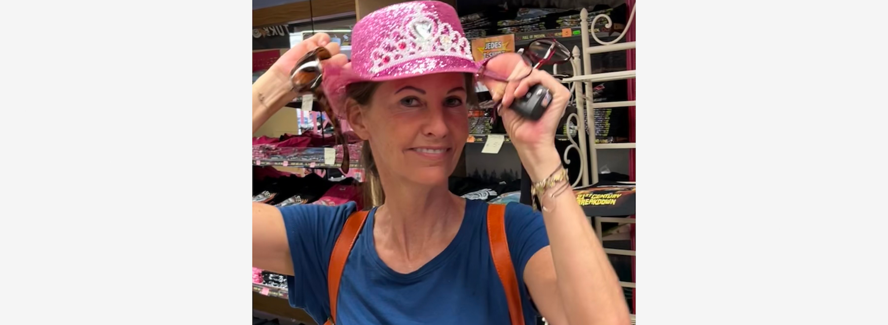 Frau mit braunen Haaren, einem bunten Schal, lächelnd vor einem Bücherregal.