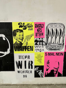 Bunte Plakate mit deutschem Text und verschiedenen karikaturistischen Illustrationen an einer Wand.